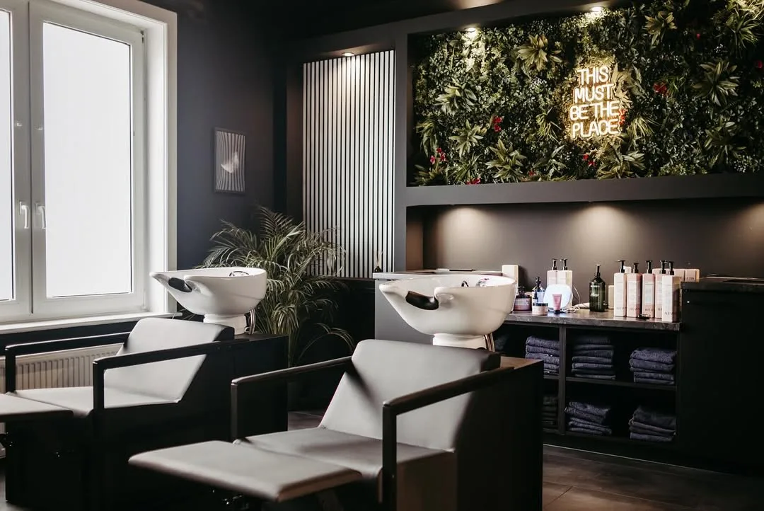 Waschbereich mit Pflanzenwand und Neonschild