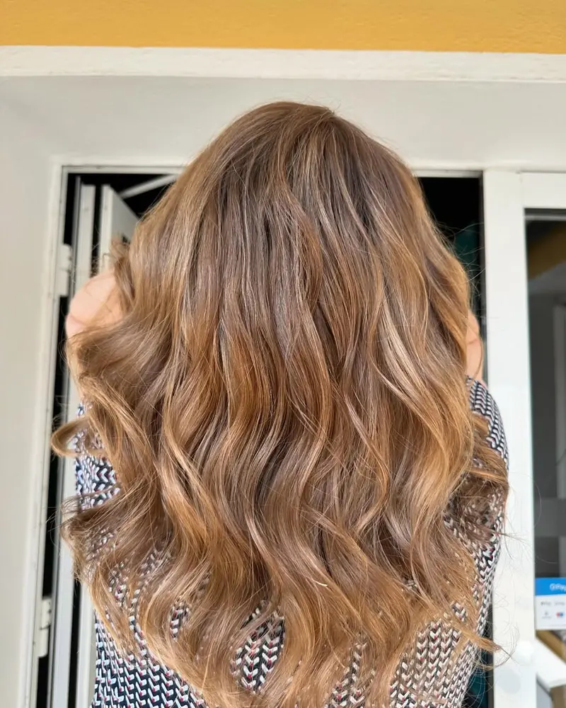 Warmes Karamell-Balayage mit natürlichen Wellen